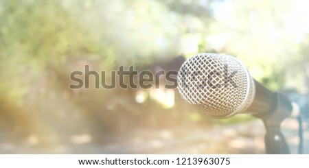 Blurred image, single microphone in the park with blurred bright light for communication concepts background