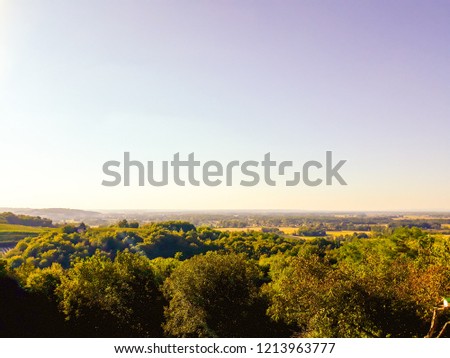 View of green forest, fields against blue sky