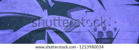 Fragment of graffiti drawings. The old wall decorated with paint stains in the style of street art culture. Colored background texture in purple tones. Royalty-Free Stock Photo #1213980034