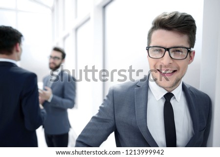 young businessman with glasses standing in the hallway office