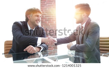 Business partners shake hands after discussing the contract