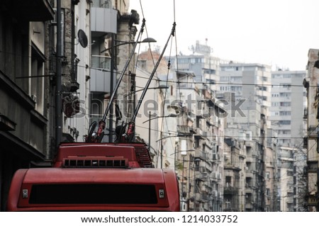 A trolley bus passing by old buildings in a grey eastern european city street of Belgrade, Serbia Royalty-Free Stock Photo #1214033752