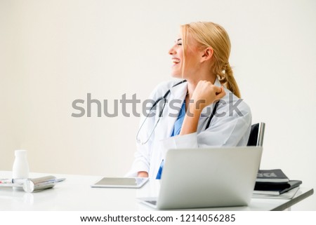 Happy successful woman doctor feels delightful in hospital or healthcare institute while working on medical report at office table. Success concept.