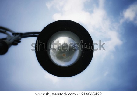 Clouds and blue sky above the light lamp hanging from the pole