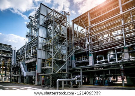 Chemical factory. Elastomer and thermoplastic production line. Vats for preparing monomers and polymerization and steel pipeline for delivering components. Royalty-Free Stock Photo #1214065939
