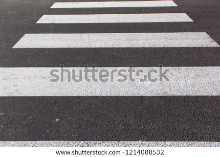 White lines of pedestrian zebra on asphalt street road