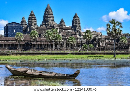 A wooden boat on front of Angkor wat with reflection on water at Siem Reap, Cambodia,Angkor Wat is a temple complex in Cambodia and one of the largest religious monuments