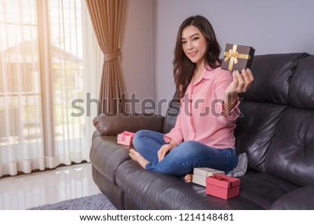 happy woman with gift box in the living room