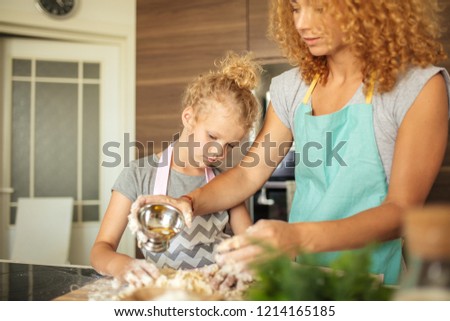 happy family in the kitchen. mother and child daughter preparing the dough, bake cookies