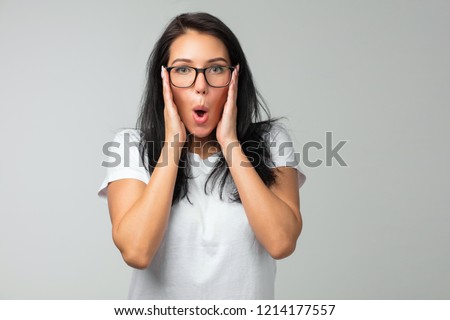 Nerdy dark-haired girl in eyeglasses grimacing at camera. Closeup of young woman in glasses touching temples and looking at the camera. close up photo. copy space