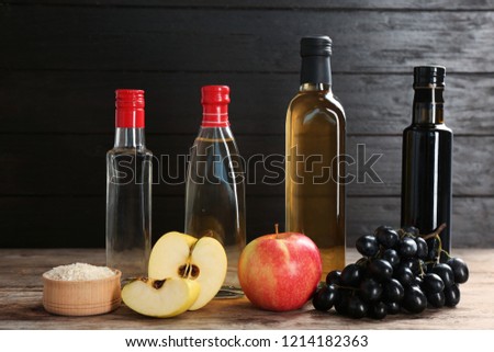Composition with different kinds of vinegar and ingredients on wooden table Royalty-Free Stock Photo #1214182363