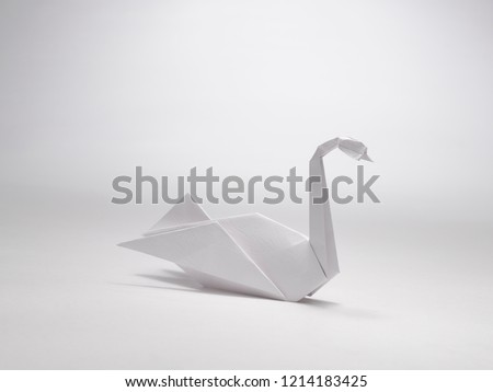 A STILL LIFE OF A PAPER SWAN MADE WITH THE ART OF ORIGAMI 
