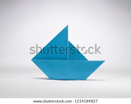 A STILL LIFE OF A PAPER SAIL BOAT MADE WITH THE ART OF ORIGAMI 

