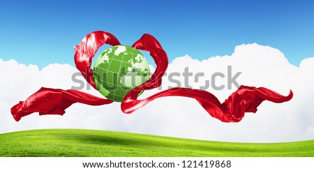 World within the heart symbol on blue sky background
