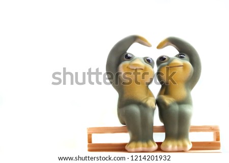 Happy  frog doll couple on wooden chair sarang hae yo isolated on white background concept valentines day.