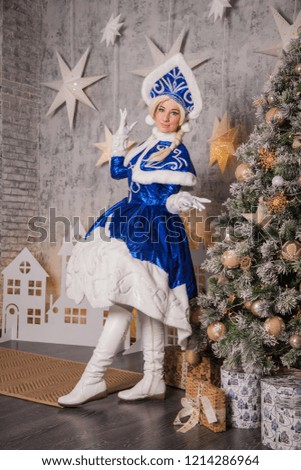 Russian Snow Maiden (Grandfather of Santa Claus) in the New Year's interior near the Christmas tree. Waiting for New Year and Christmas
