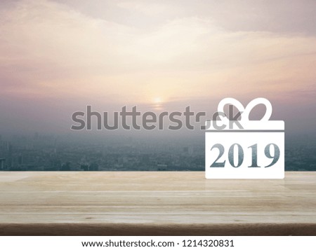 Gift box happy new year 2019 flat icon on wooden table over modern city tower and skyscraper at sunset, vintage style, Business shop online concept