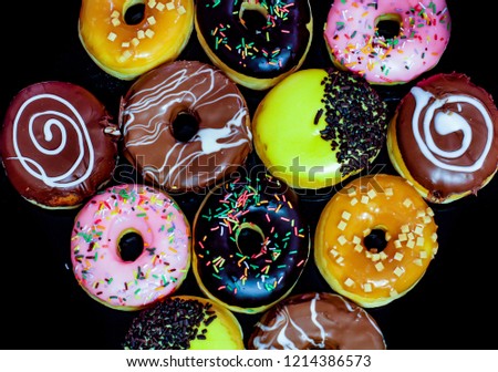 Selection of Tasty and deliciously looking donuts on black background
