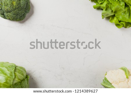 Stone background with a border of fresh vegetables.  Top view.