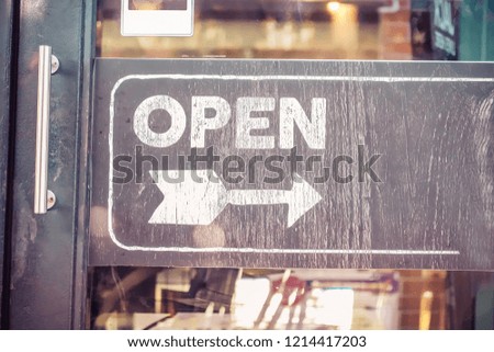 Open sign board through the glass of restaurant door. Business service and food concept. Vintage tone filter color style.