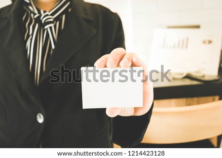 A girl holding a white business card for business contacts.