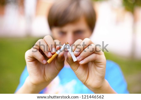 Young boy breaks a cigarette. Selective focus.