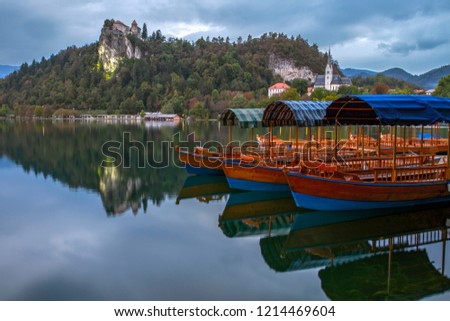Tourist boats on the on Lake Bled. Beautiful mountain lake Bled and Medieval castle on the rock. Scenery at Bled lake in Slovenia. Mountains in background. Slovenia, Europe. European travel.