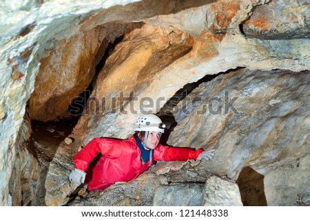 A portrait of a young female caver exploring the cave Royalty-Free Stock Photo #121448338