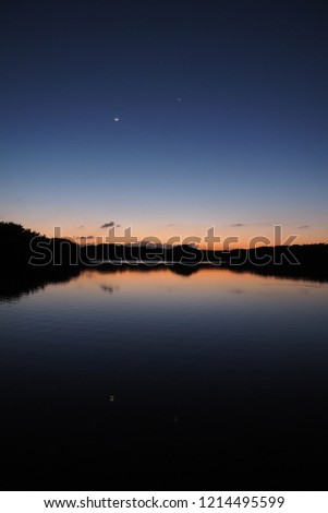 The Moon and Venus over an exceptionally calm Paurotis Pond in Everglades National Park, Florida, in late twilight.