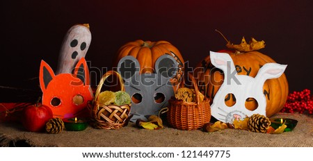 Trick or treat halloween masks and  buckets filled with cookies on color background