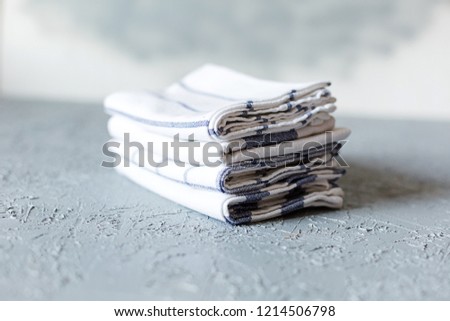 A pile of kitchen cotton napkins on grey concrete background. Copy space.