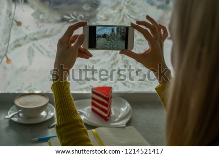 Person is taking photo with a smartphone. Close-up image of female hands using smartphone on coffee shop, searching or social networks concept, hipster girl sends an image to her friends.