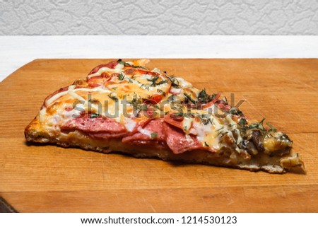 Italian rustic pizza, one piece on a wooden tray, white wooden table.