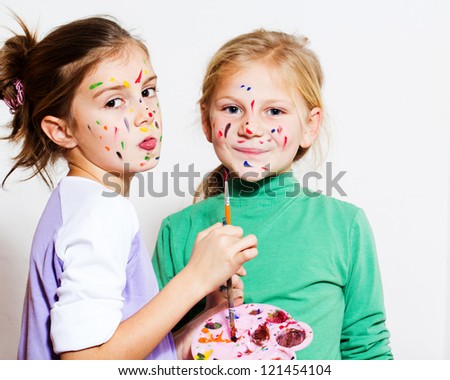 Two little girls painting and have a fun