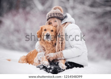 retriever sitting with a girl in the snow