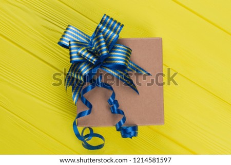 Cardboard kraft gift box. Top view. Yellow wood background.