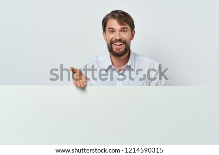 smiling man standing behind white mockup                       