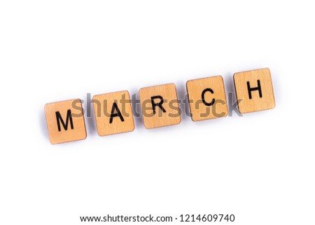 MARCH, spelt with wooden letter tiles over a plain white background. 