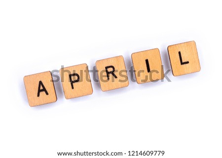 APRIL, spelt with wooden letter tiles over a plain white background. 
