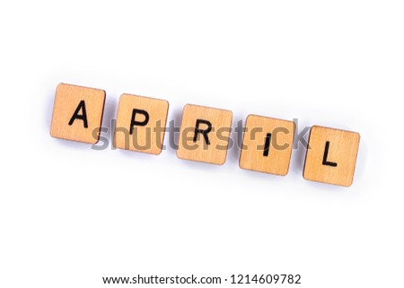APRIL, spelt with wooden letter tiles over a plain white background. 