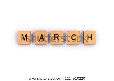 MARCH, spelt with wooden letter tiles over a plain white background. 