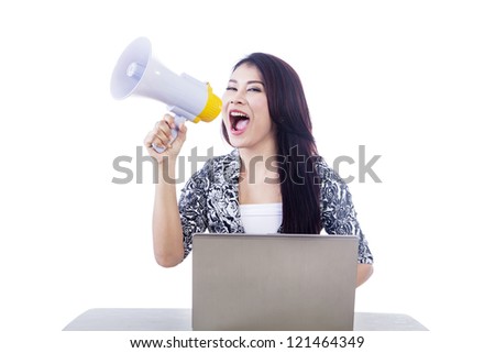 Beautiful woman holding speaker while using laptop isolated over white