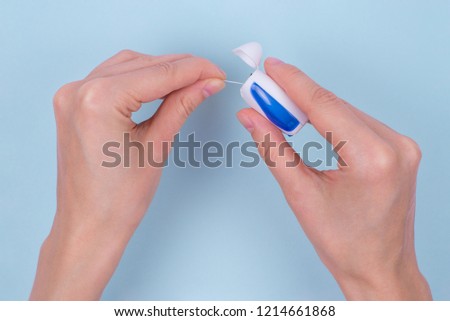 Flatlay flat lay high top angle view above overhead close up photo of lady's hands holding dental floss isolated on light background copy space copyspace