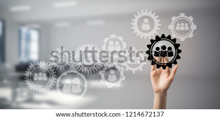 Close of woman hand touching gears on screen with palm and office at background