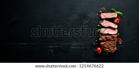 Beef steak. Veal, meat. On a black wooden background. Top view. Free copy space.
