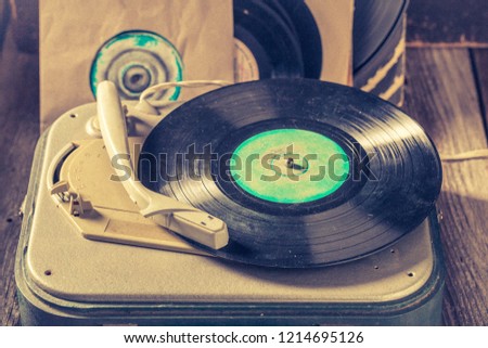Vintage record player and vinyls as toned and filtered photo
