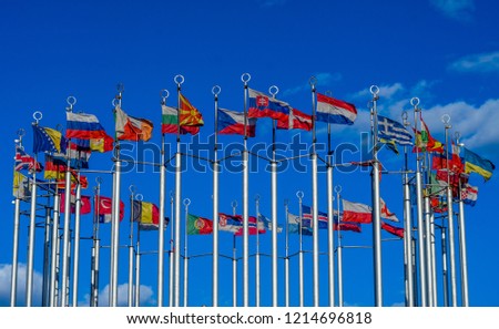 Flags of European countries on flagpoles against the blue sky.