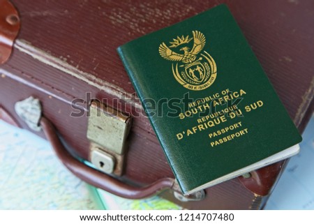 A South African passport on top of a vintage travel bag. Travel or immigration concept image. 