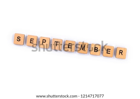 SEPTEMBER, spelt with wooden letter tiles over a plain white background. 