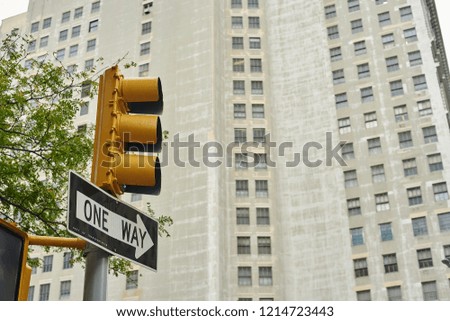 one way sign under traffic light in front of building